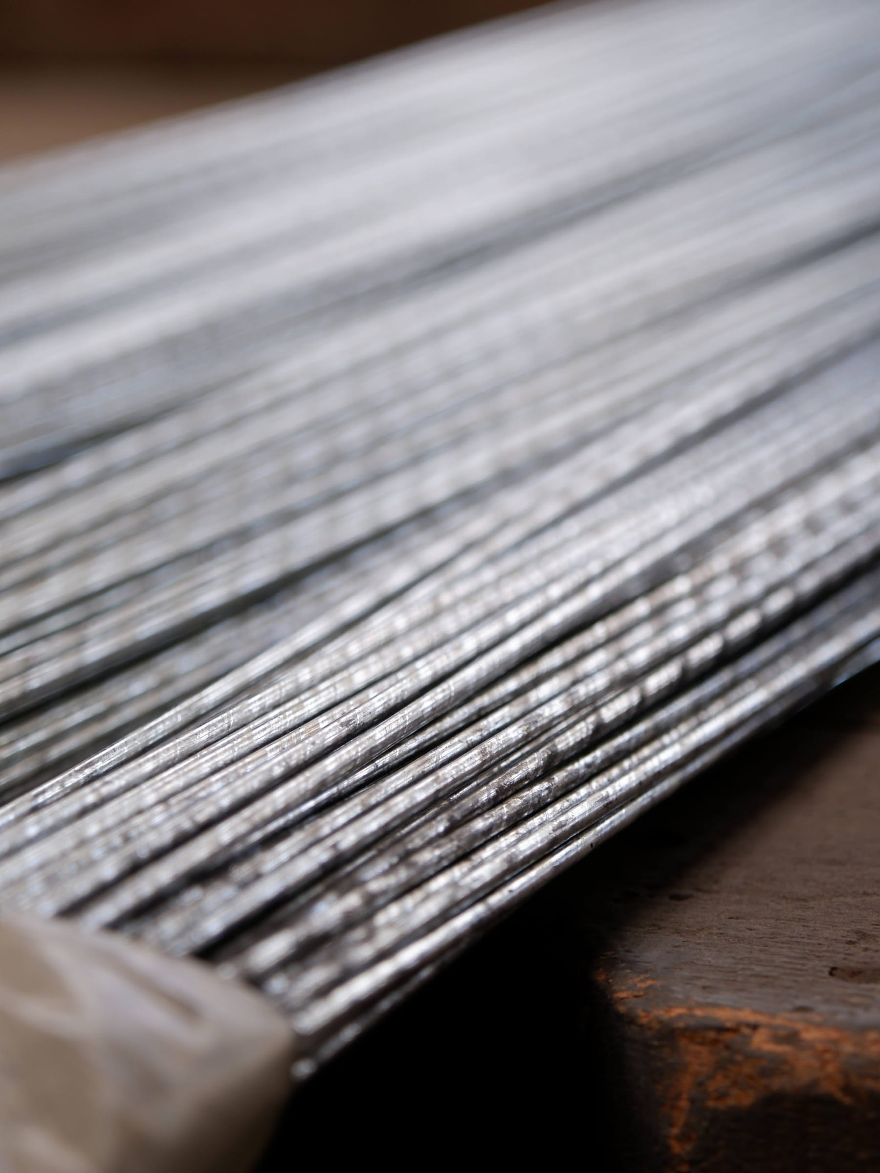 Close-up of straight cut baling wire on a wooden work surface